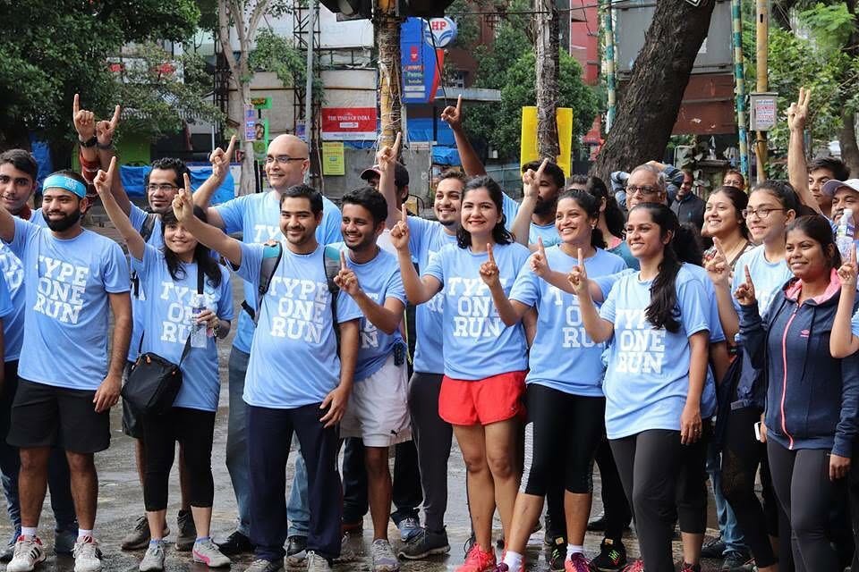 The Pune chapter of Type One Run on a city street after a run, arms raised.